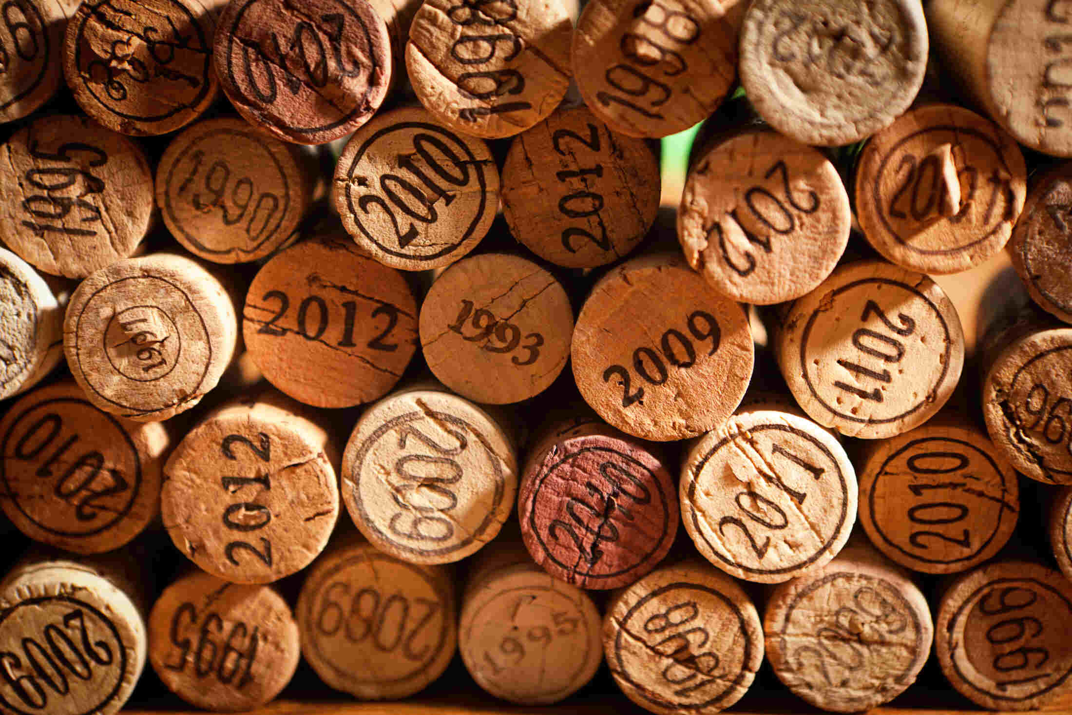 A spread of aged wine corks stamped with vintage years